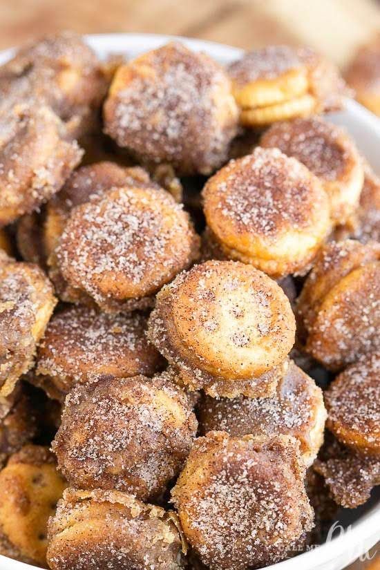 a bowl filled with sugared pastries on top of a wooden table