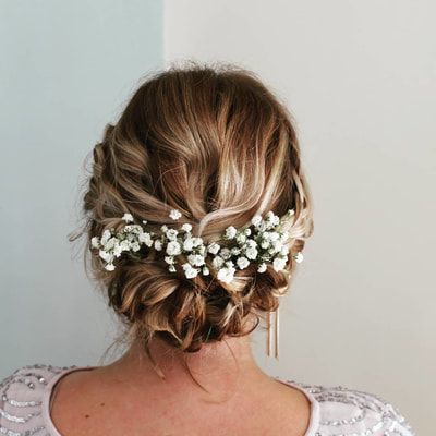 a woman with flowers in her hair is wearing a white dress and has a flower crown on her head