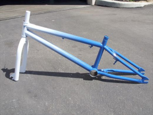 a blue and white bicycle frame laying on the ground