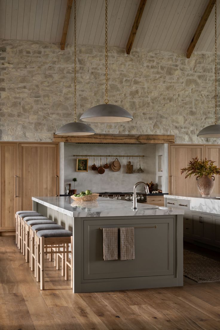 a large kitchen with an island in the middle and stools at the counter top