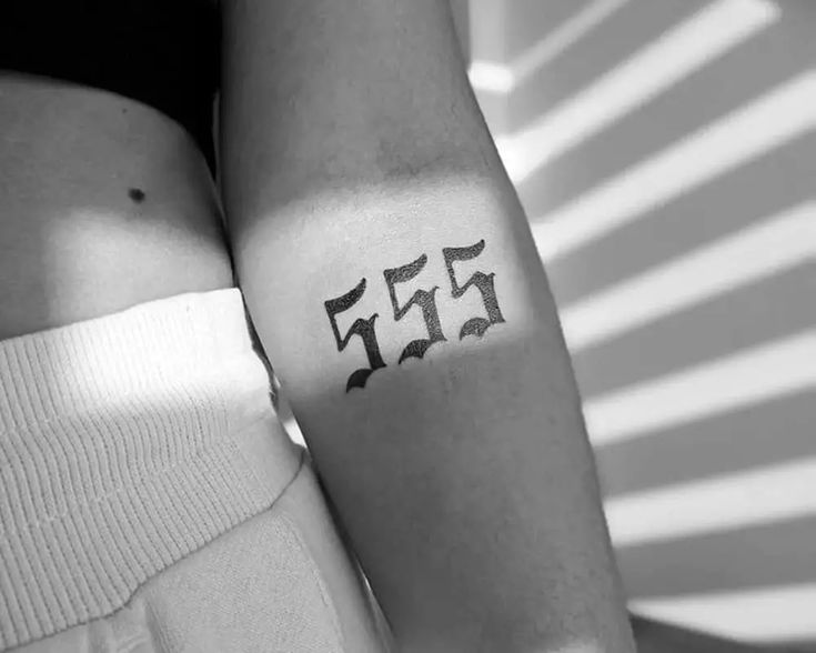 a woman's arm with the number 55 on it and an arrow in the middle