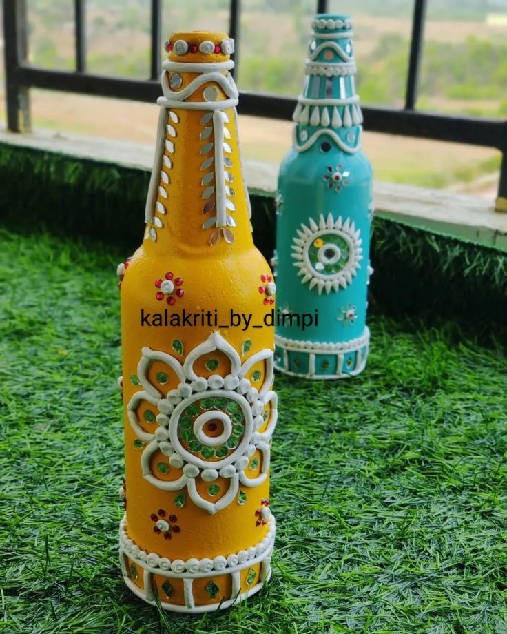 two colorful bottles sitting on top of green grass