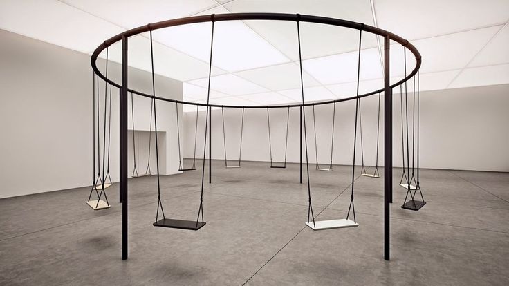 an empty room with swings in the middle