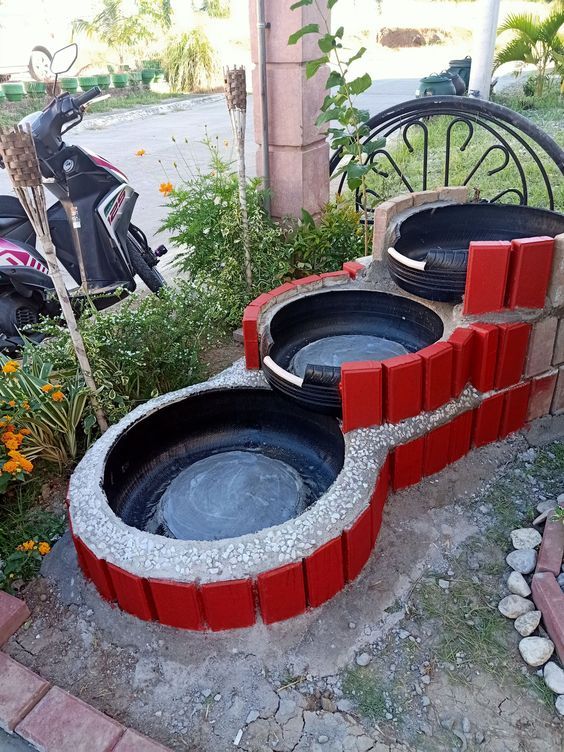 an outdoor fountain made out of bricks and water in front of a scooter