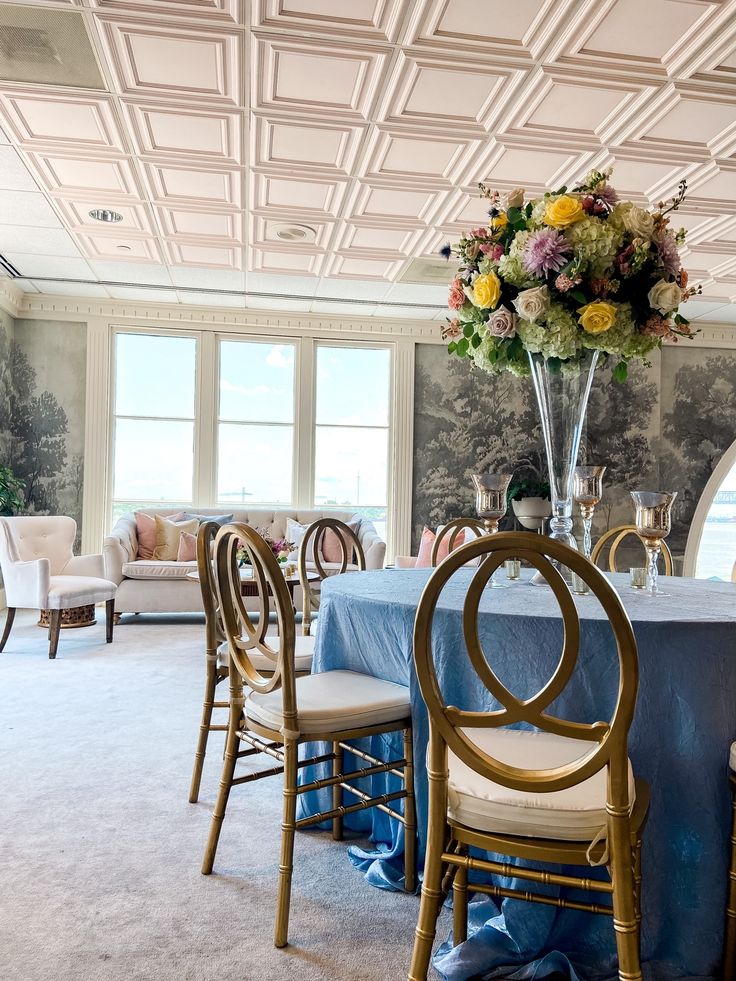 a dining room table with chairs and a vase filled with flowers