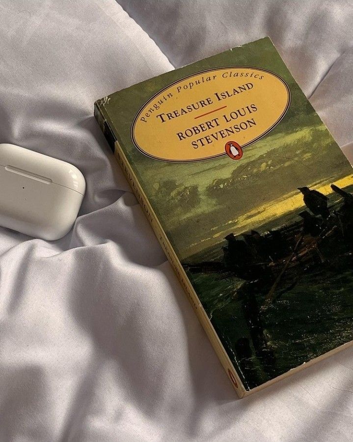 there is a book on the bed next to an object that looks like a remote control