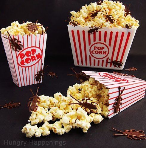 three red and white striped popcorn boxes with chocolate sprinkles