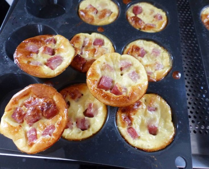 several muffins with ham and cheese in a pan