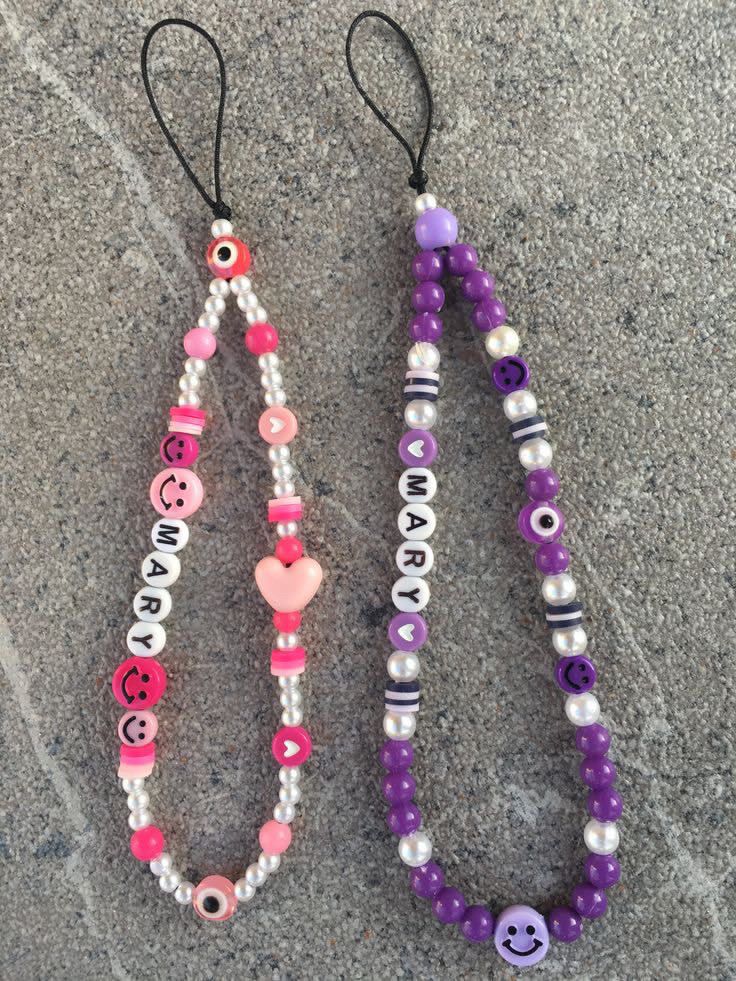 two necklaces made out of beads with smiley faces and hearts hanging from the strings