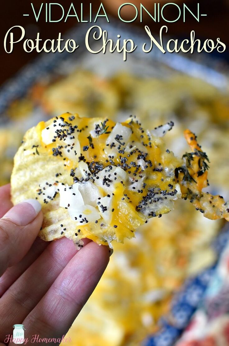 a hand holding up a cracker with cheese and black pepper