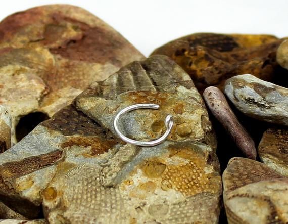 a silver ring sitting on top of some rocks