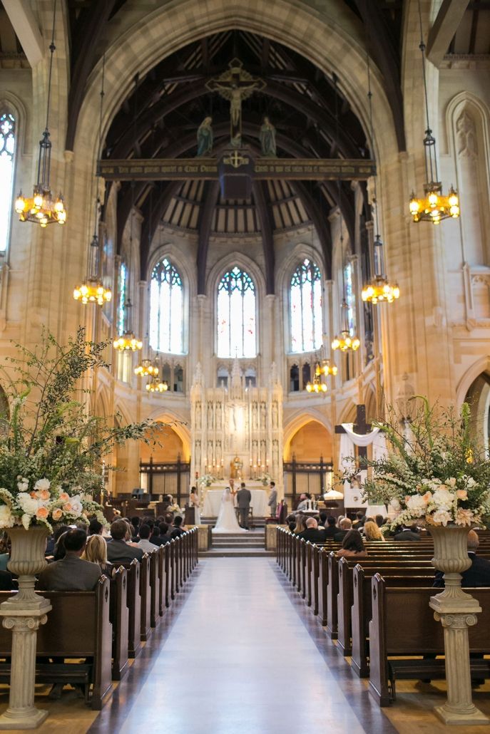 the inside of a church with pews and flowers in vases on each side