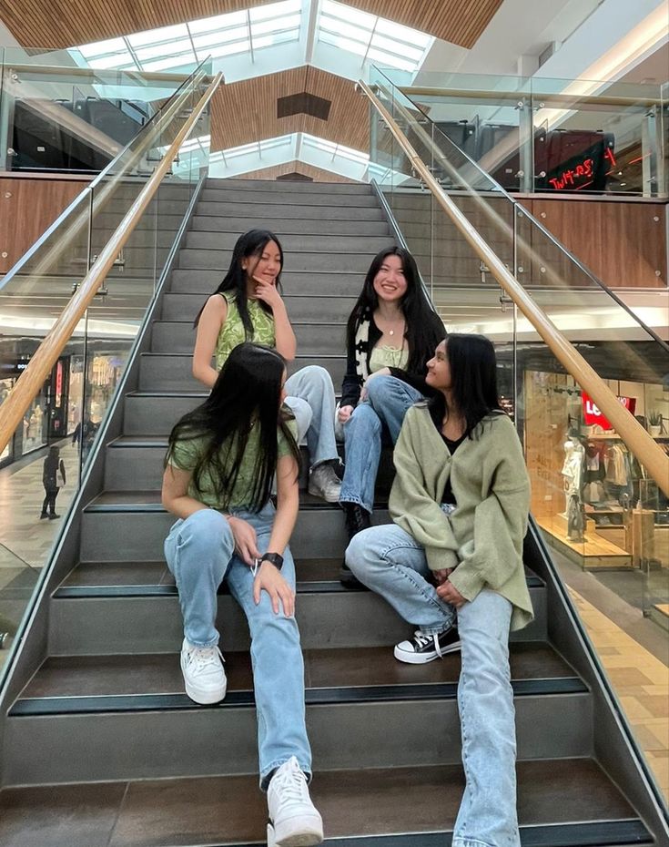 three women sitting on the stairs in a mall