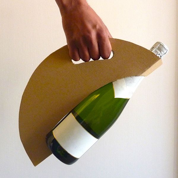 a person is holding a wine bottle on top of a cardboard board