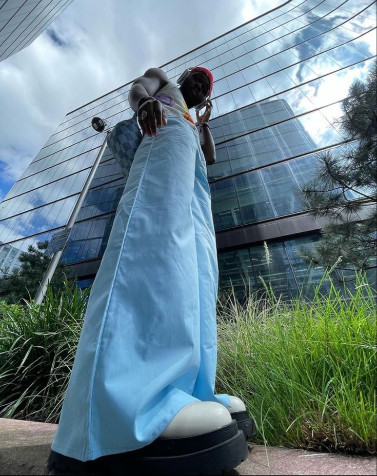 a statue with a blue cloth draped around it's body in front of a tall building