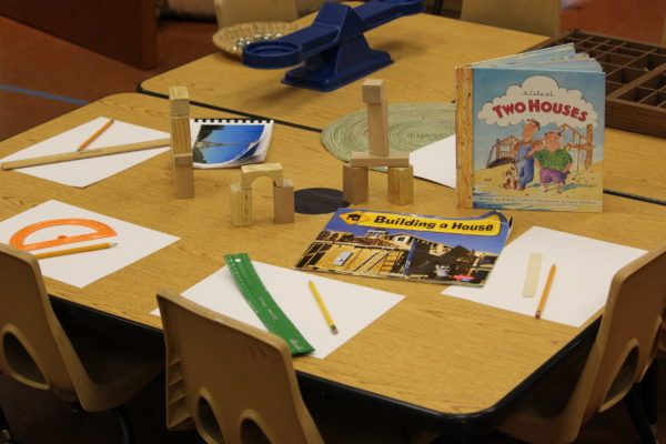 there is a table that has some books and pencils on it, along with other school supplies