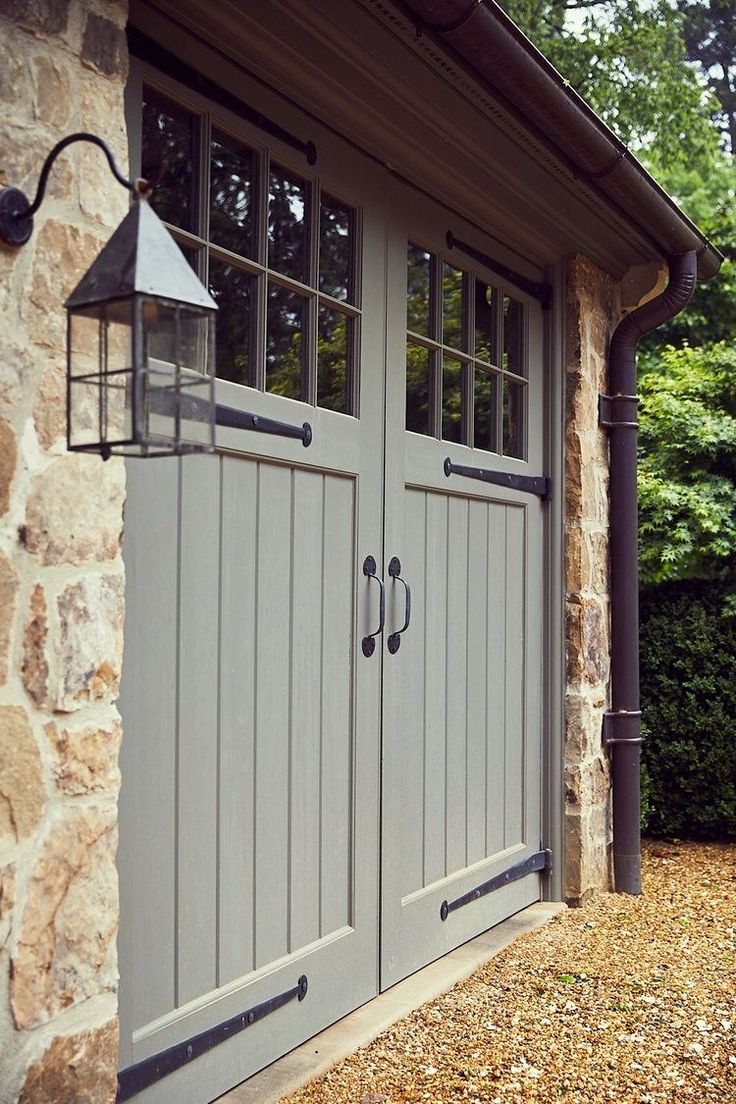 a stone building with two doors and a lamp on the outside