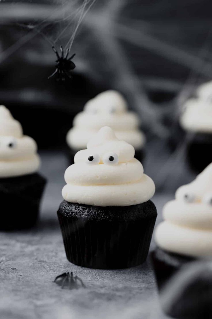 black cupcakes with white frosting and spooky eyes