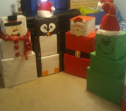 christmas presents are stacked on top of each other with santa's hats and penguins