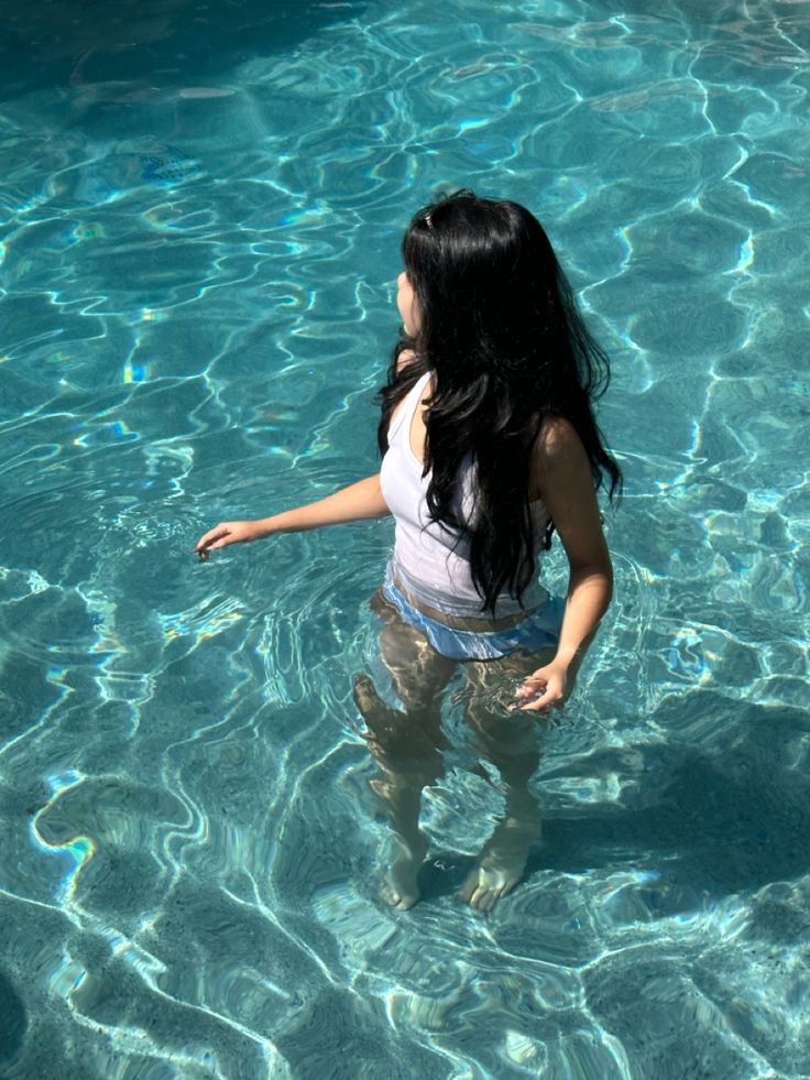 a woman standing in the water with her hand out