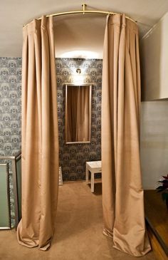 a room with curtains and a mirror in the corner that is open to reveal a dressing area