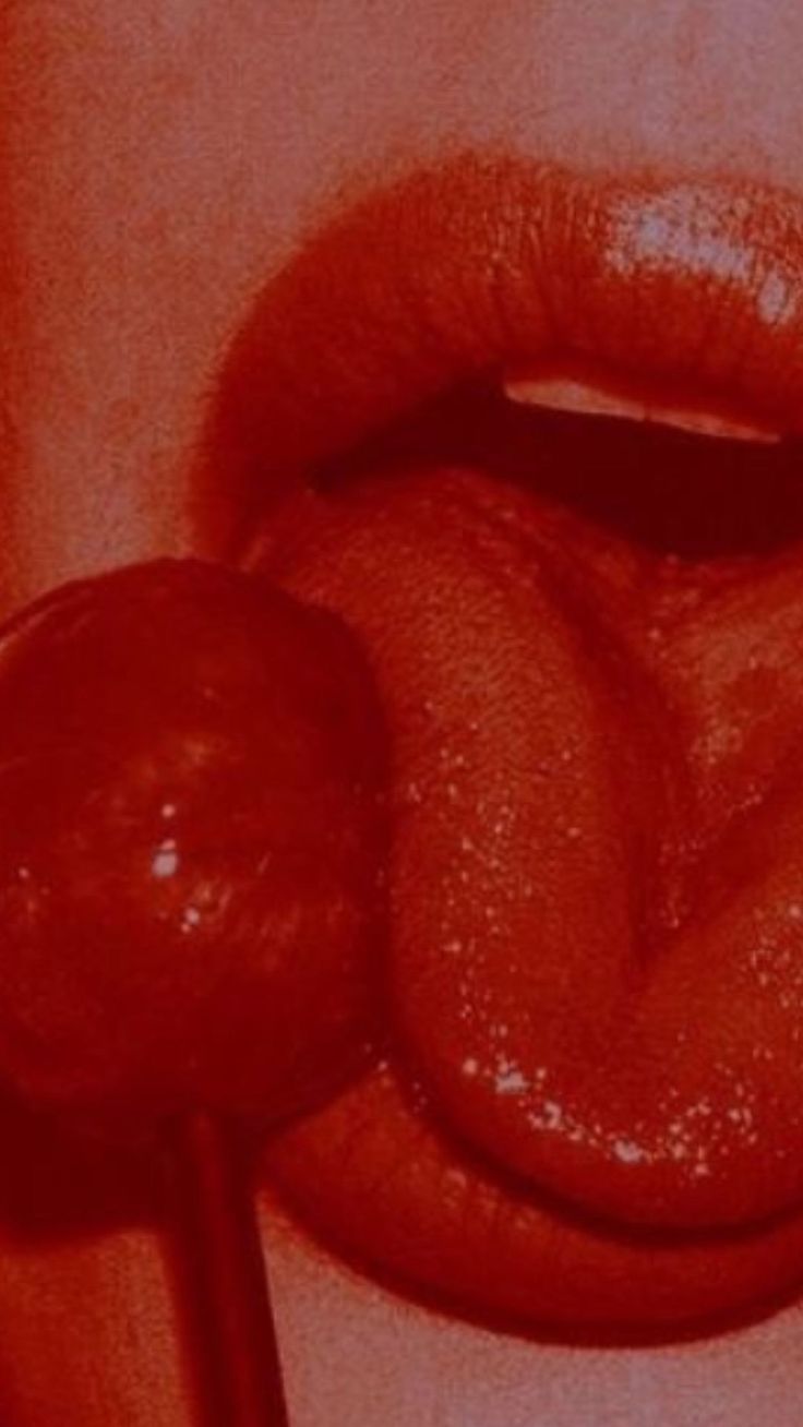 a close up of a person's lips with a candy lollipop in the middle