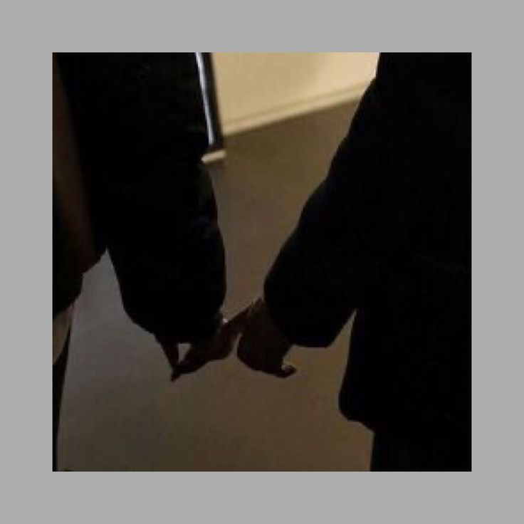 two people holding hands in front of a door with the reflection of another person's hand