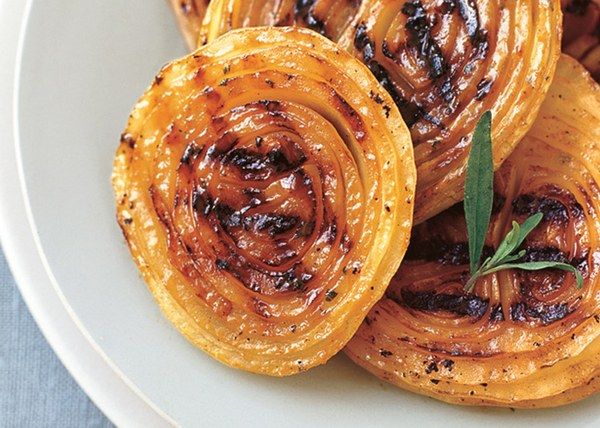 grilled onions on a white plate with herbs