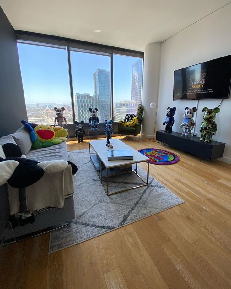 a living room with hardwood floors and large windows looking out onto the cityscape