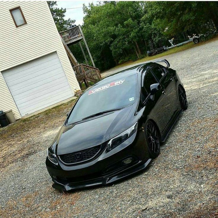 a black car parked in front of a garage