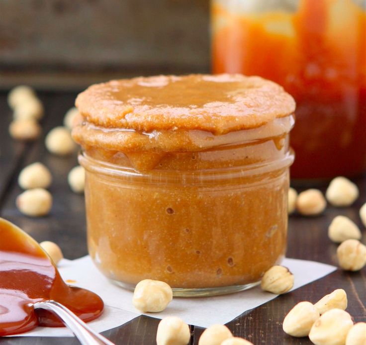 peanut butter in a jar with peanuts around it