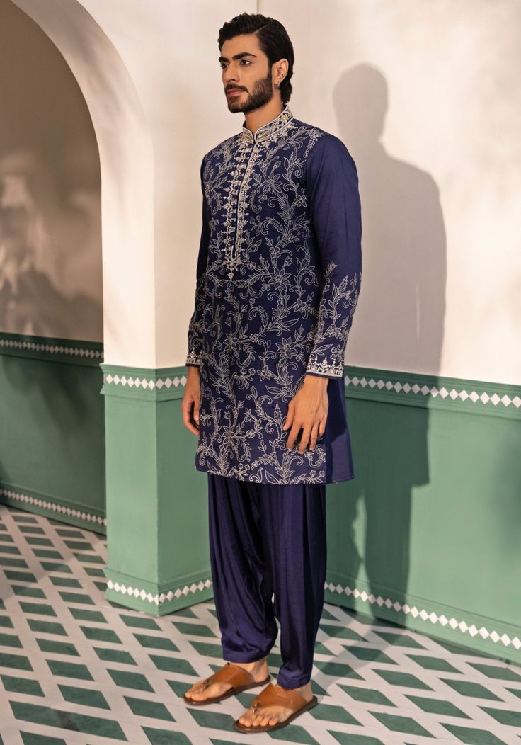 Elevate your style with the Navy Blue Silk Kurta Set. Crafted from luxurious silk, it features a concealed placket and intricate hand embroidery with beading, thread, sequence, and cutdana work. Includes matching pyjamas to complete the look. Perfect for Sangeet, Mehendi or as a wedding guest. Composition : Padma Silk Care: Dry Clean Only and Vacuum Storage This product can be customized for sleeves, length and colour Delivery : 4-6 weeks as the product is hand crafted. Check Size Guide or choose MySize for free customisation (All Sizes above XL can be made at 15% additional cost) For more information and sizes please contact fabiliciousfashion@gmail.com or visit our Copenhagen studio. About the Designer : Shreyansh, a distinguished designer label specializing in luxurious ethnic menswear Blue Kurta With Intricate Embroidery For Reception, Blue Embroidered Sherwani For Reception, Blue Embroidered Bandhgala For Designer Wear, Diwali Blue Bandhgala With Intricate Embroidery, Blue Kurta With Chikankari Embroidery For Reception, Blue Chikankari Embroidered Kurta For Reception, Blue Chikankari Embroidery Kurta For Reception, Blue Bandhgala With Intricate Embroidery For Designer Wear, Blue Chikankari Embroidered Bandhgala For Reception