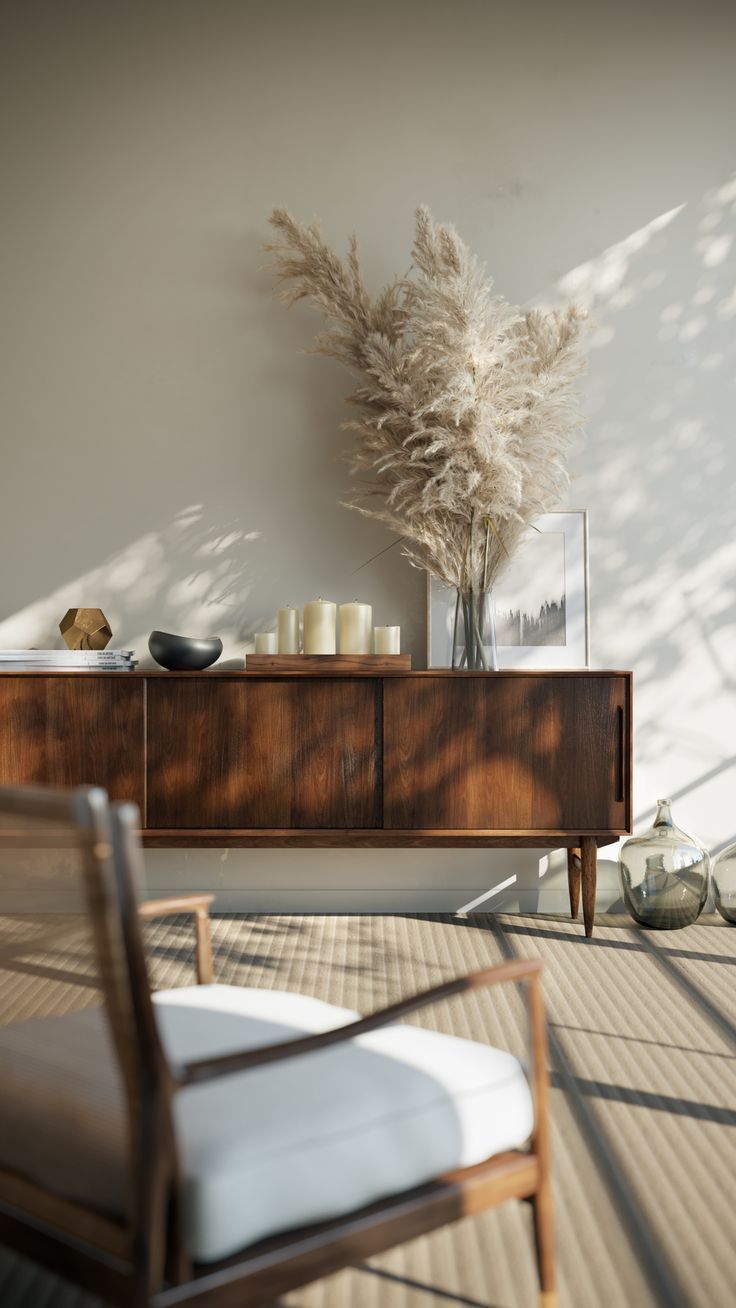 a room with a chair, table and vase on top of the dresser next to it