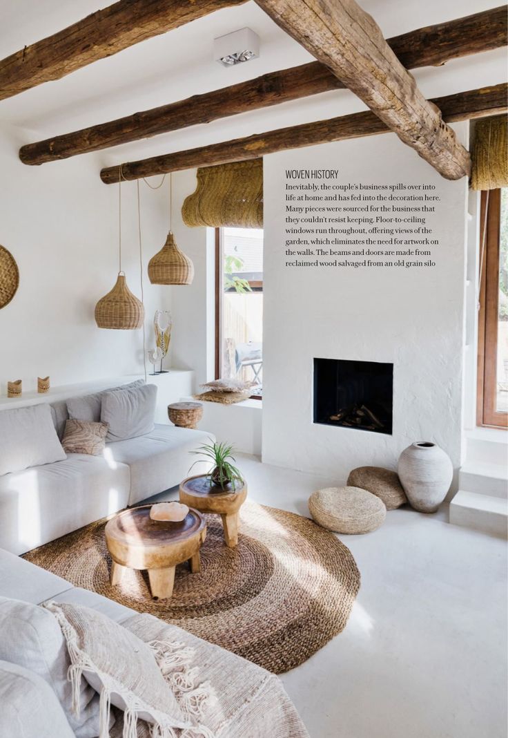 a living room with white walls and wooden beams