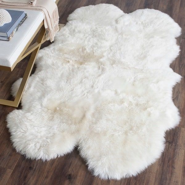 a white sheepskin rug sitting on top of a wooden floor