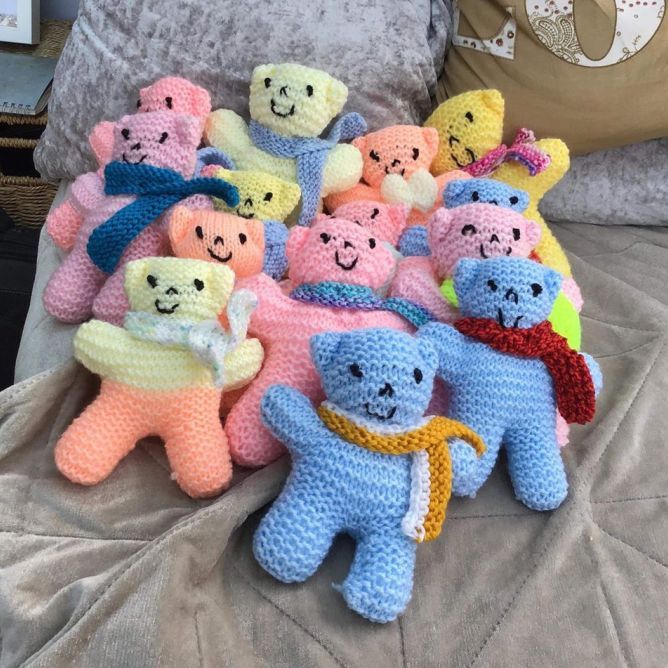 there are many crocheted teddy bears on the bed