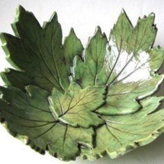 a green leaf shaped bowl sitting on top of a table