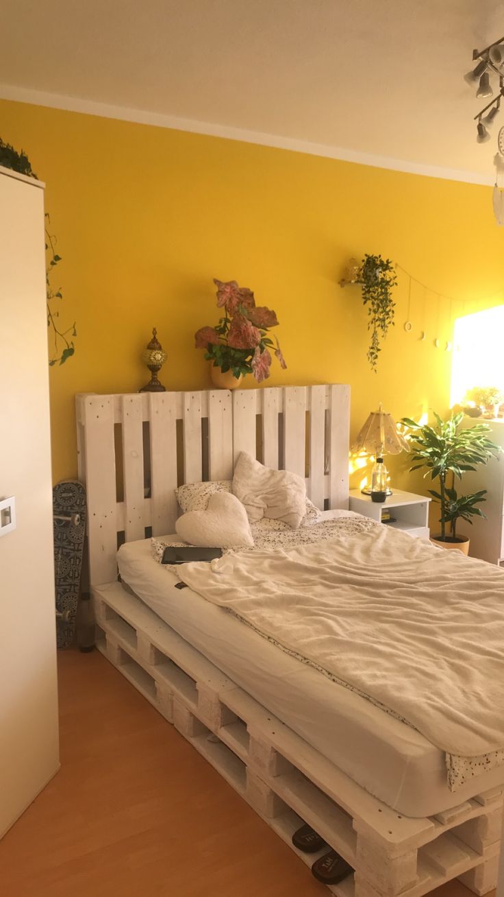 a bed made out of pallets in a yellow room