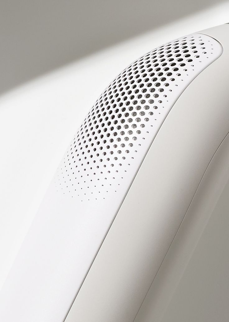 an air purifier sitting on top of a white wall next to a window