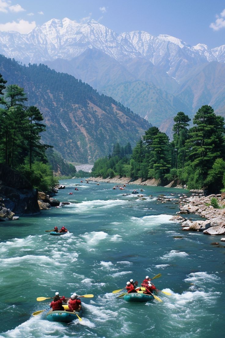 several people are rafting down a river with mountains in the background