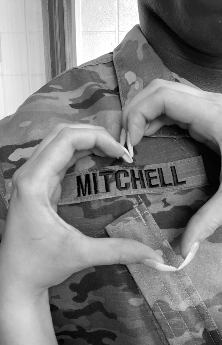 two hands that are holding something in the shape of a heart with the word mitchell written on it