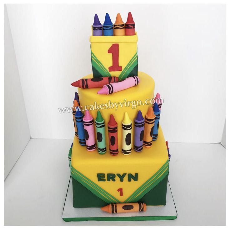 a birthday cake with crayons on it and the number one in the middle