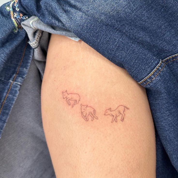 a woman's thigh with three small horses on the back of her leg,