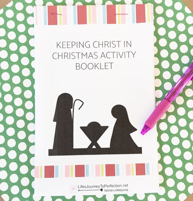 a christmas activity book with a pink pen next to it on a polka dot tablecloth