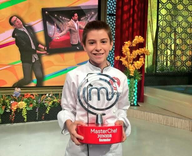 a young boy holding up a trophy in front of a tv screen with the word master and margarita on it