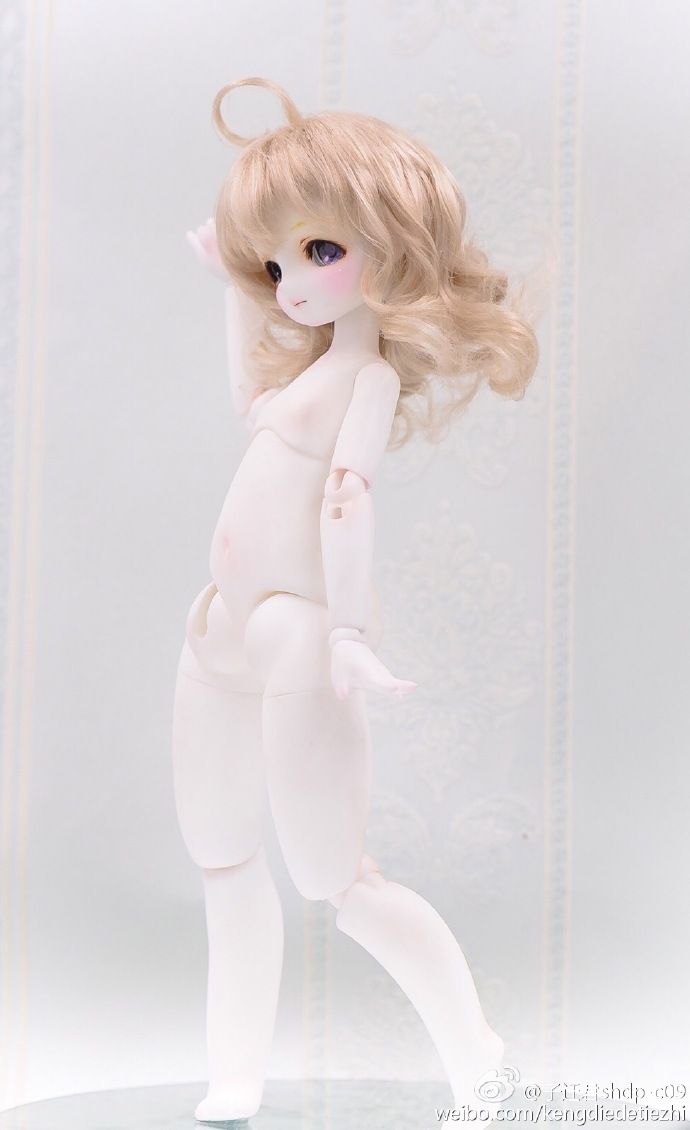 a white doll with blonde hair is posed