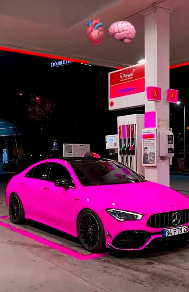 a pink car is parked at a gas station