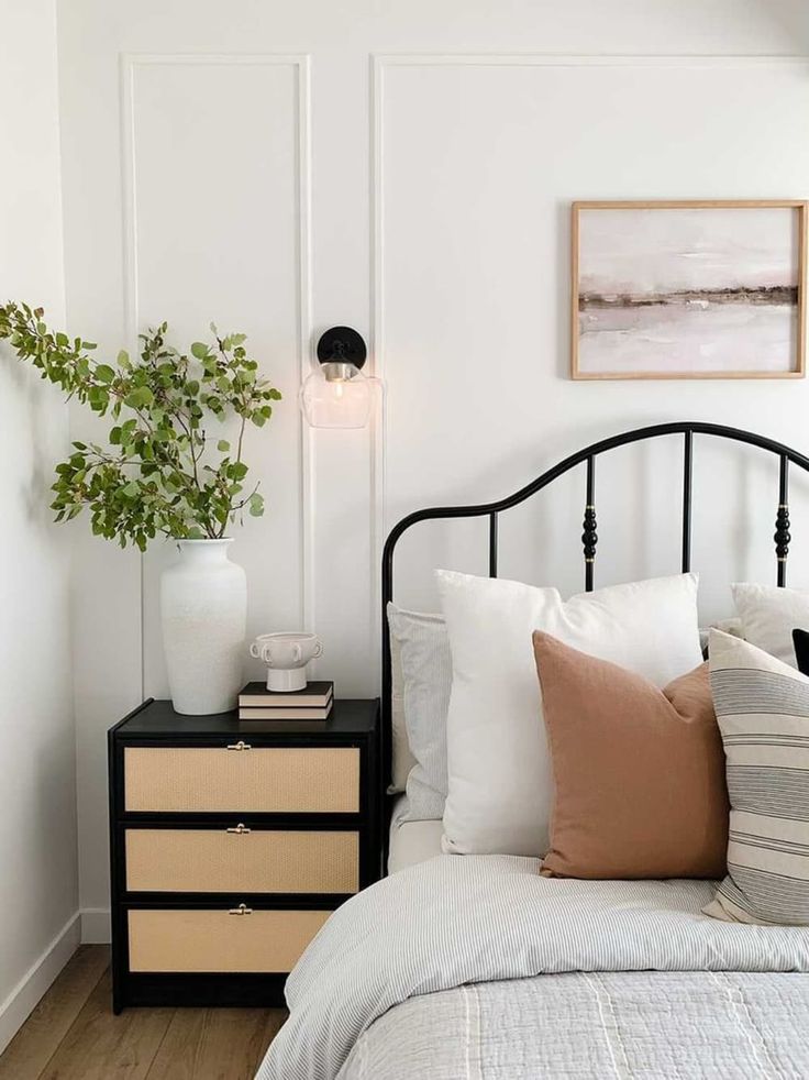 a bedroom with white walls and black bed frame