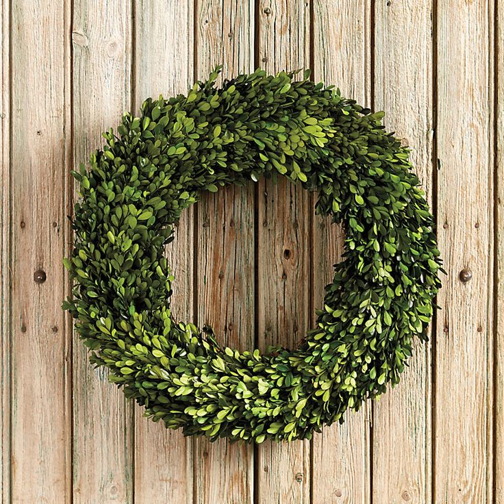 a wreath is hanging on the side of a wooden wall