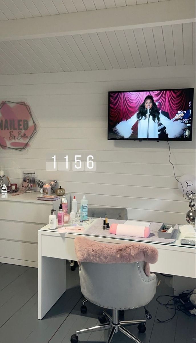 a white desk with a tv on top of it and pink fur rug in front of it